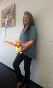 A library staff member stands with Spearow, a birdlike pokemon.