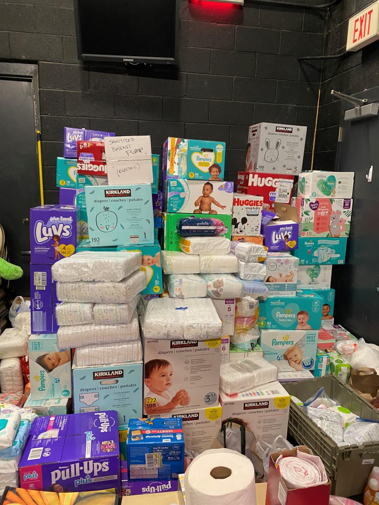 Critical items like diapers, baby wipes, toilet paper stacked and ready for those in need.