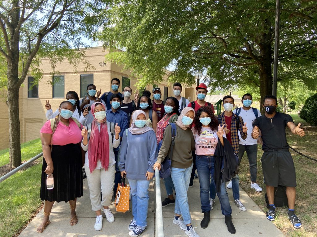 Annandale Campus Community College Initiative students wearing masks smile and wave.