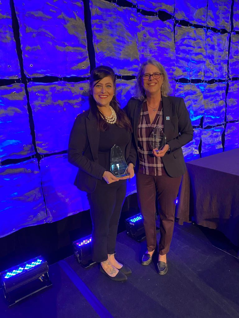 Photo: Dr. Cynthia Pascal and Dr. Kim Grewe accept awards on behalf of NOVA at the Online Learning Consortium (OLC).