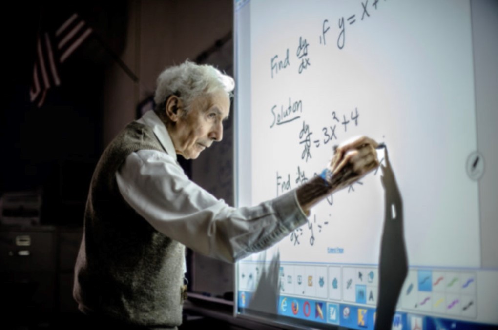 ACPS Photo: Louis Kokonis writes on the smart board while teaching math class