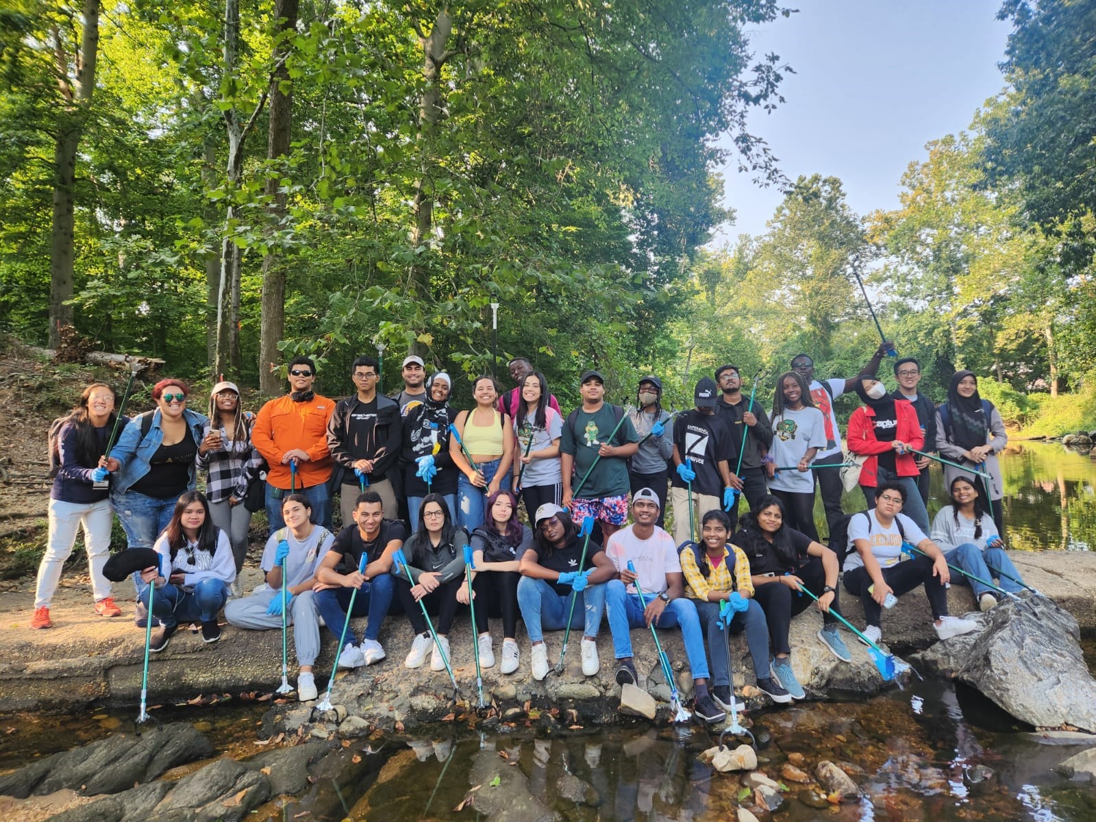 All 30 participants for the community service project pose for a photo in front of a creek bed.