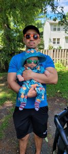 Esports Coach Jordan Whitaker holds his baby boy.