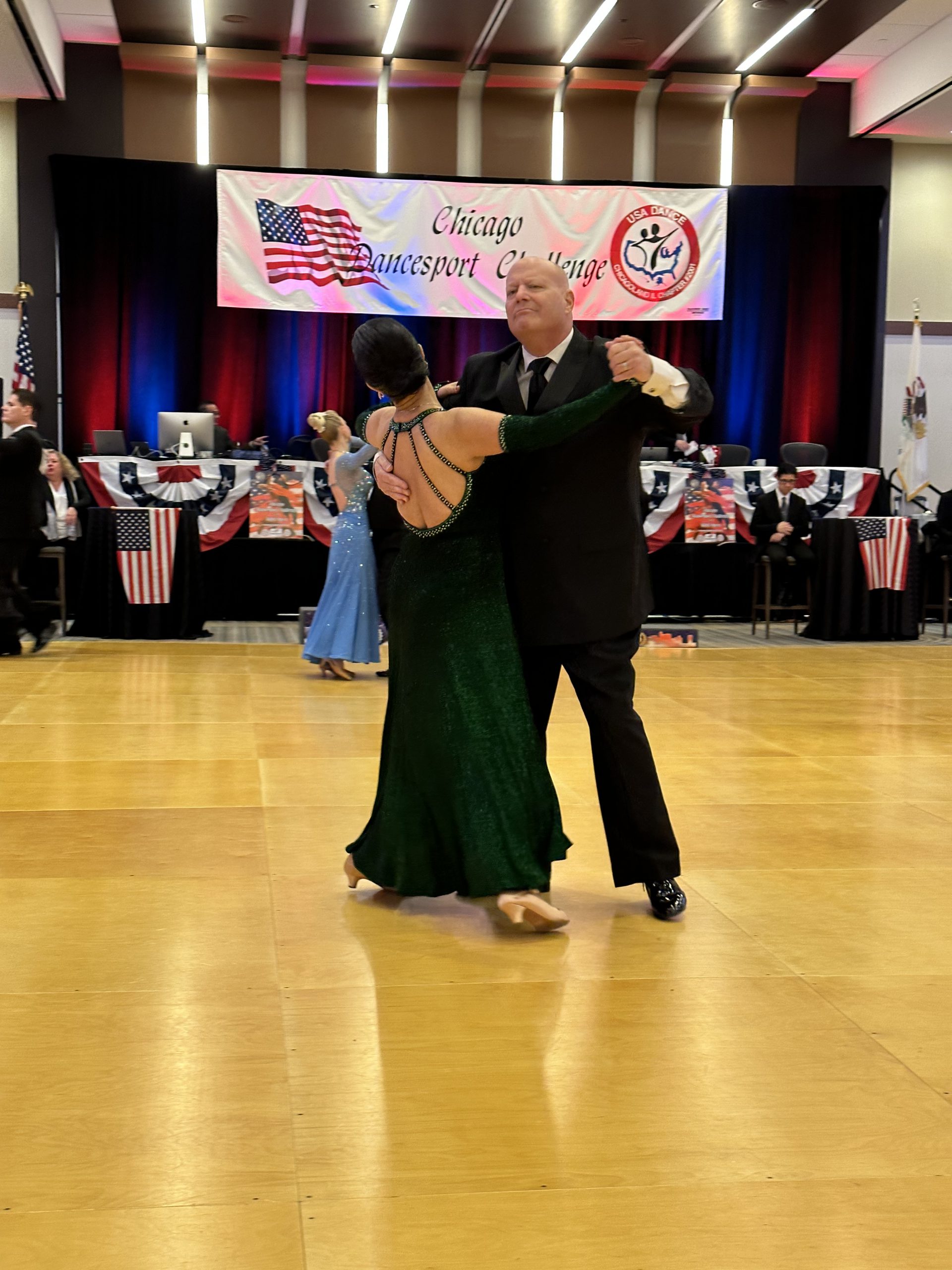 Golombek and his wife Thuy sachet across the dance floor with judges in the background.