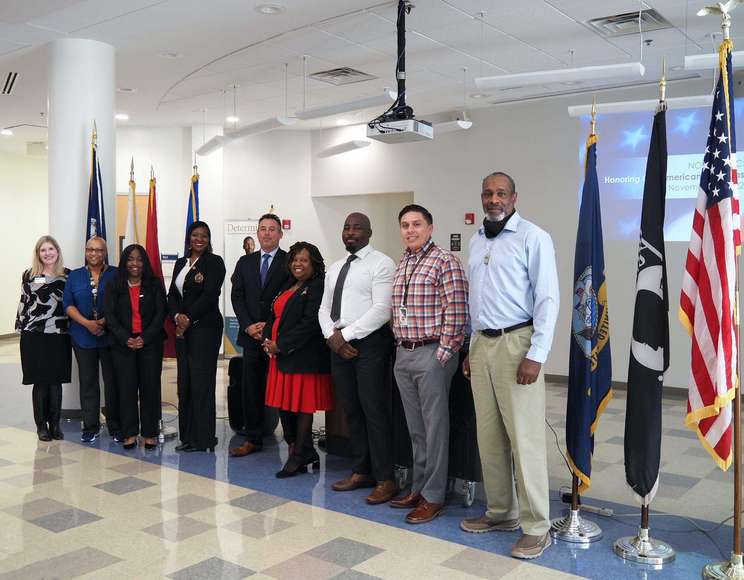 Photo of participants lined up in the Medical Education Campus first floor Forum. Left to right: Executive Director of the NOVA Educational Foundation Kelly Persons, Program Director of Radiology Jarice Risper, MEC Provost Shelly Powers, Director of Military and Veteran Services Dr. Takesha McMiller, Transurban North America's Chief Financial Officer Michael Discenza, Interim Dean of Student Success Kimberly Nicely, Navy Veteran and MEC Veterans Advisor Ellis Colleton, Military and Veterans Program Advisor Luis Charboneau and Fall Cohort Administrative Assistant Eric Shaw.