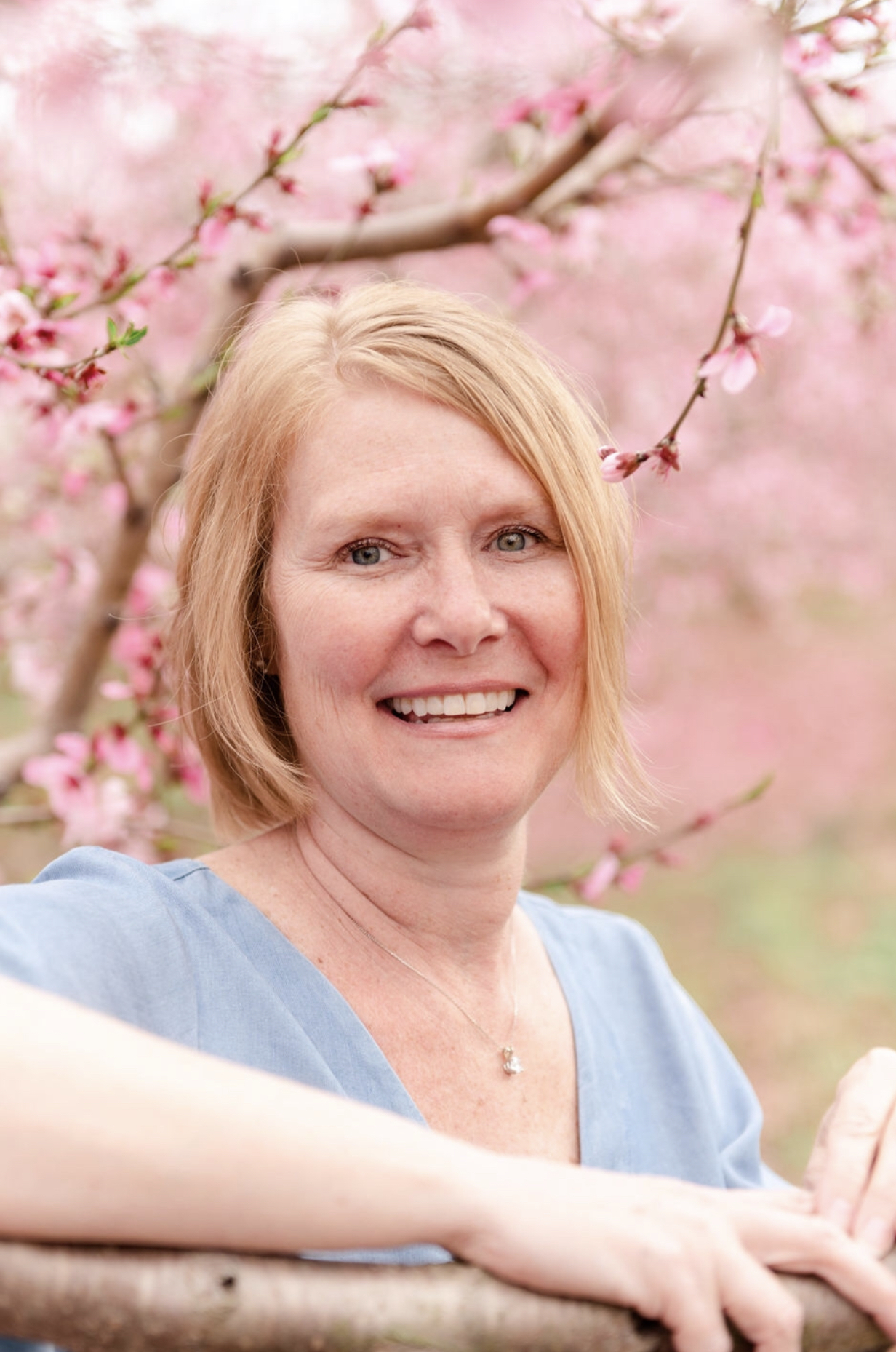 Marina McGraw poses in front of beautiful spring cherry blossoms