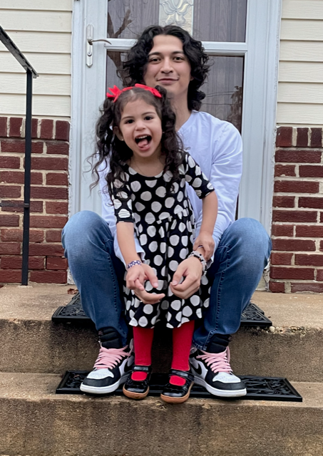 Christopher Aviles Sanchez sits on the front steps of his home with his little sister.