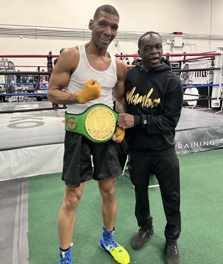 Keith Sowell stands just outside the boxing ring and shows off his Title Boxing Belt win