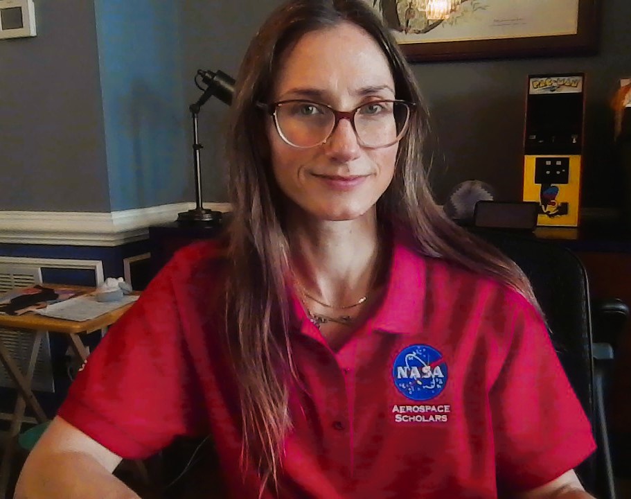Shannon Left sits quietly at her desk wearing her red polo with a bright blue NASA Aerospace Scholars logo.