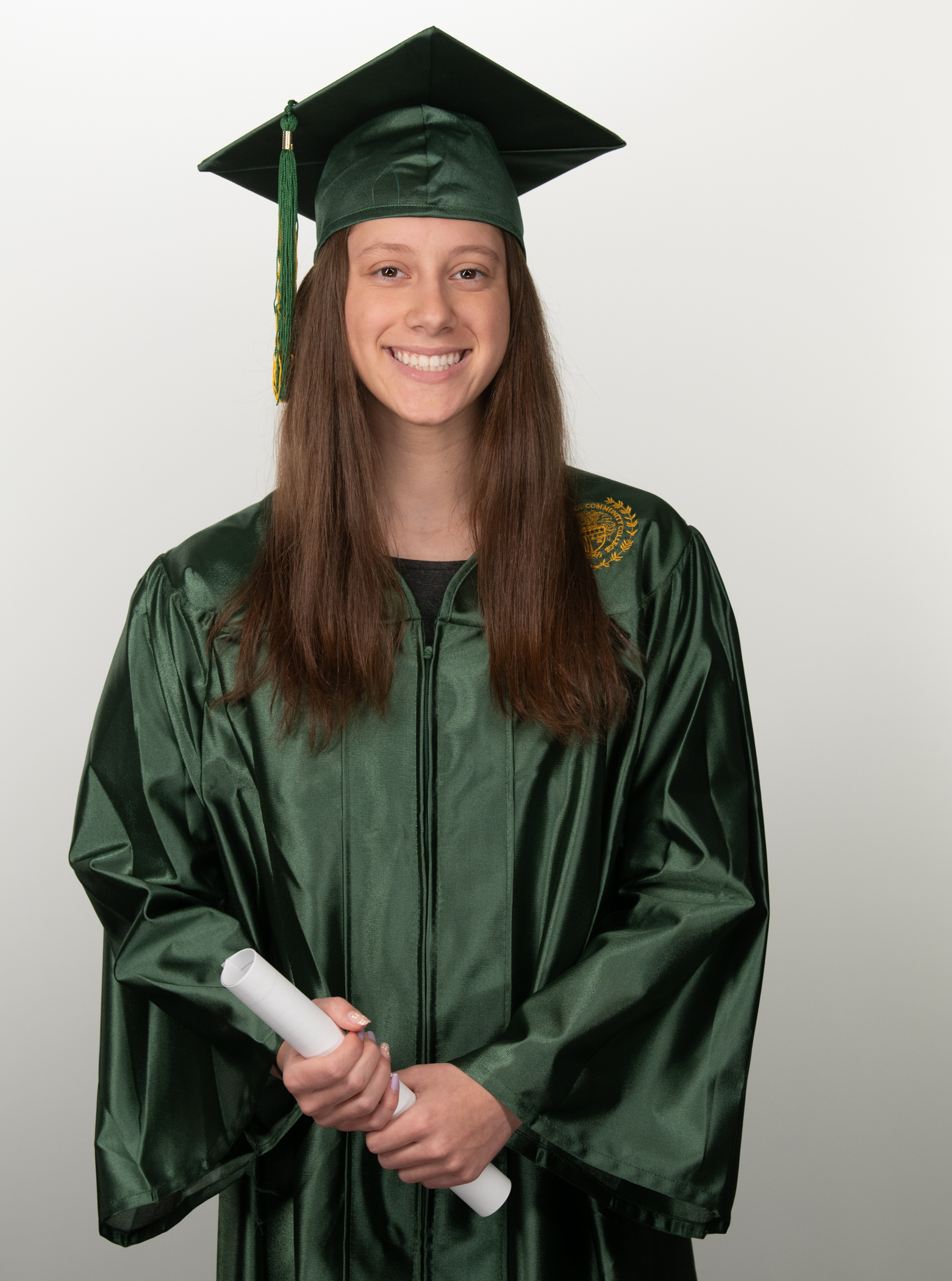17-year-old Sydney Guthrie smiles while wearing her graduation robe and motar board.