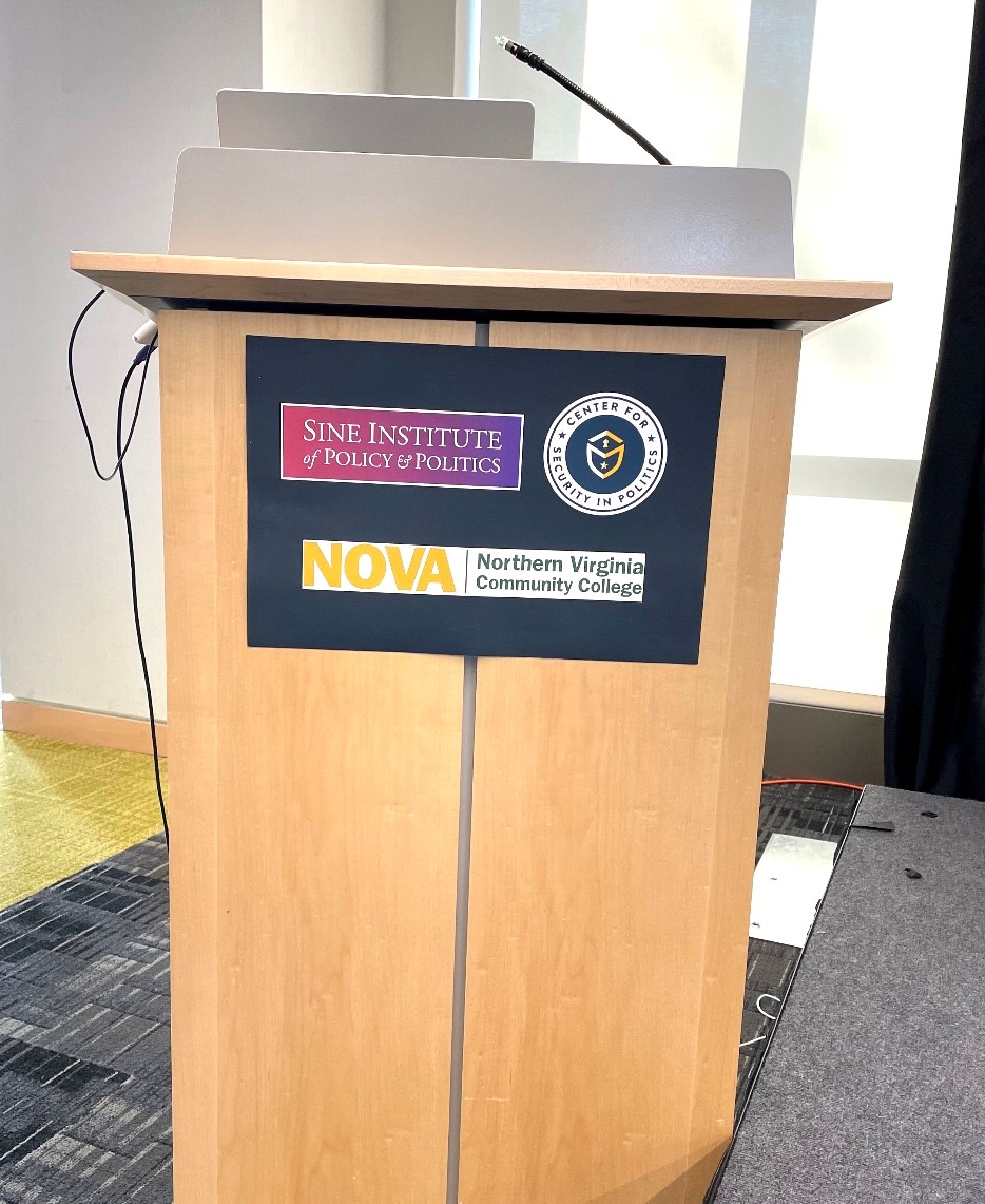 The podium displays the three participating institutions' logos, "Sine Institute of Policy & Politics," "The Center for Security in Politics" and "NOVA, Northern Virginia Community College."