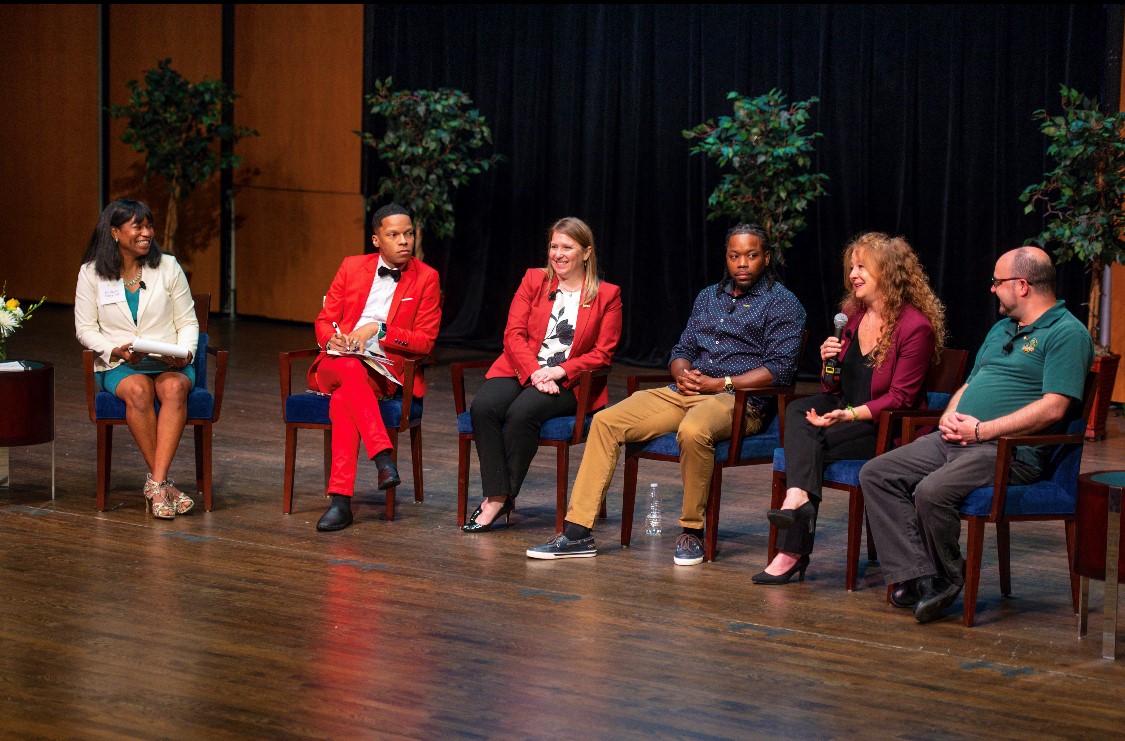 Panel of faculty and staff assembled on stage at the Schlesinger Center at NOVA's Alexandria Campus. Left to right: moderators Dr. Dahlia Henry-Tett, chief wellness officer and Terrell Strayhorn; Amanda Wilder, associate director of government and community relations; C.J. Jackson, associate director of athletics; Indigo Eriksen, English, Woodbridge Campus; Steven Lessner, English, Annandale Campus