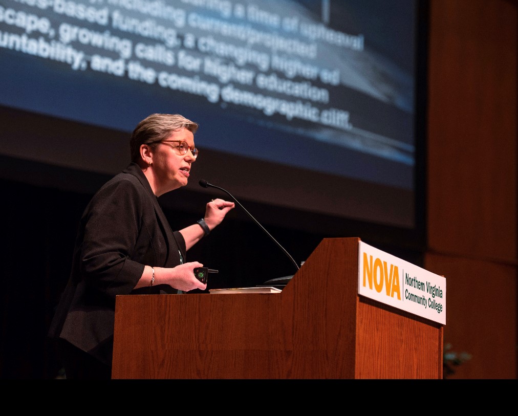 President Anne Kress stands at the podium presenting details of the Strategic Plan 2023-2026