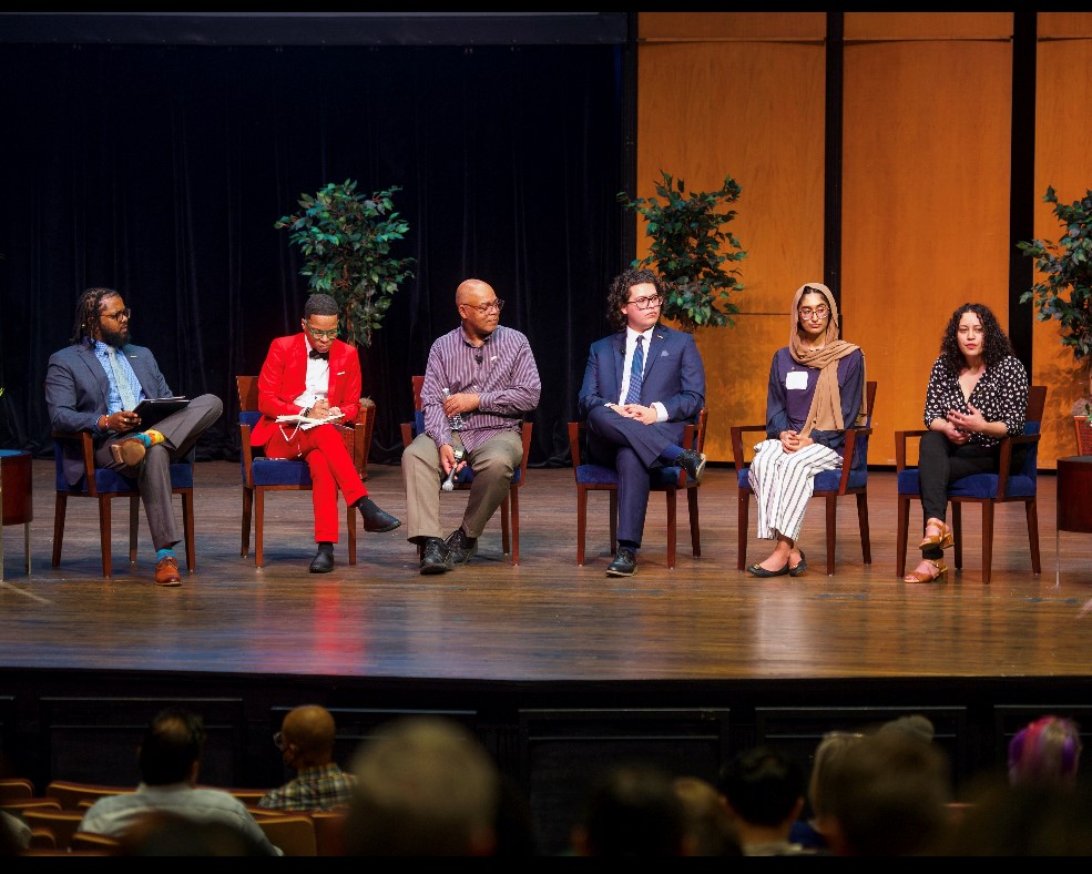 The student panel assembled on stage with ficus trees in the background: Left to right: Nigel Word, Terrell Strayhorn and students Willie Brown, Jason Menjivar, Zaynab Mirza and Tel El Houda Trad