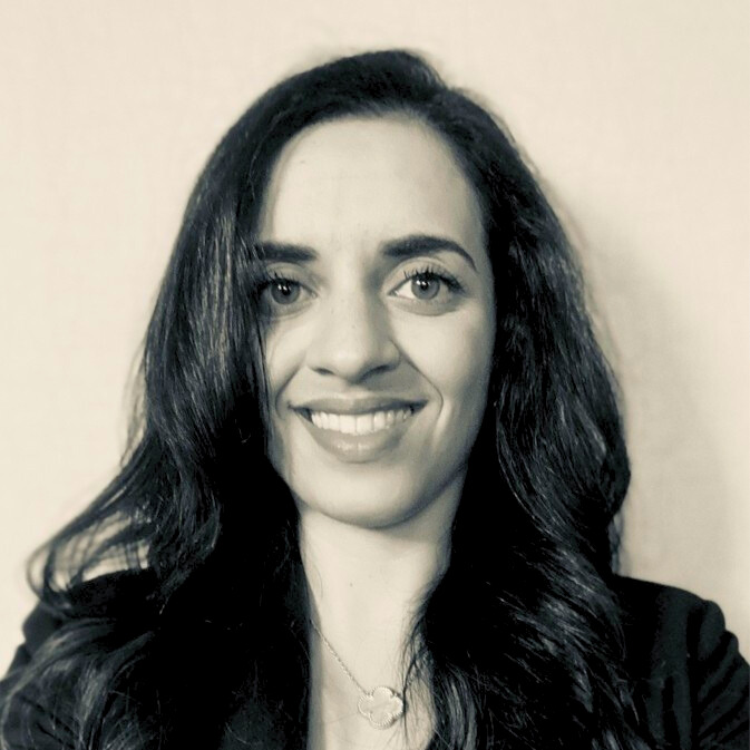NOVA alumna Sogand Rahmani smiles for the camera in a black-and-white photograph.