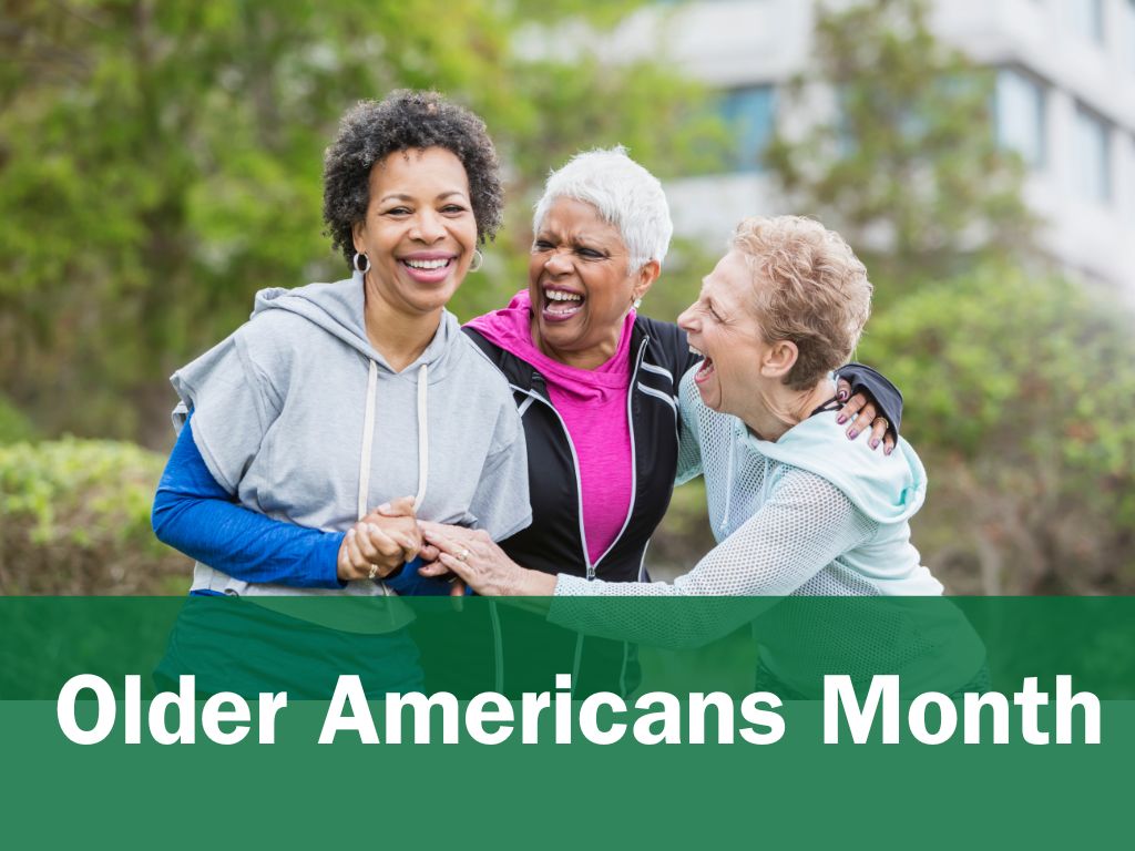 Photograph of three older women wearing athletic clothing while smiling outside. Below photo, in white text against green background: "Older Americans Month"