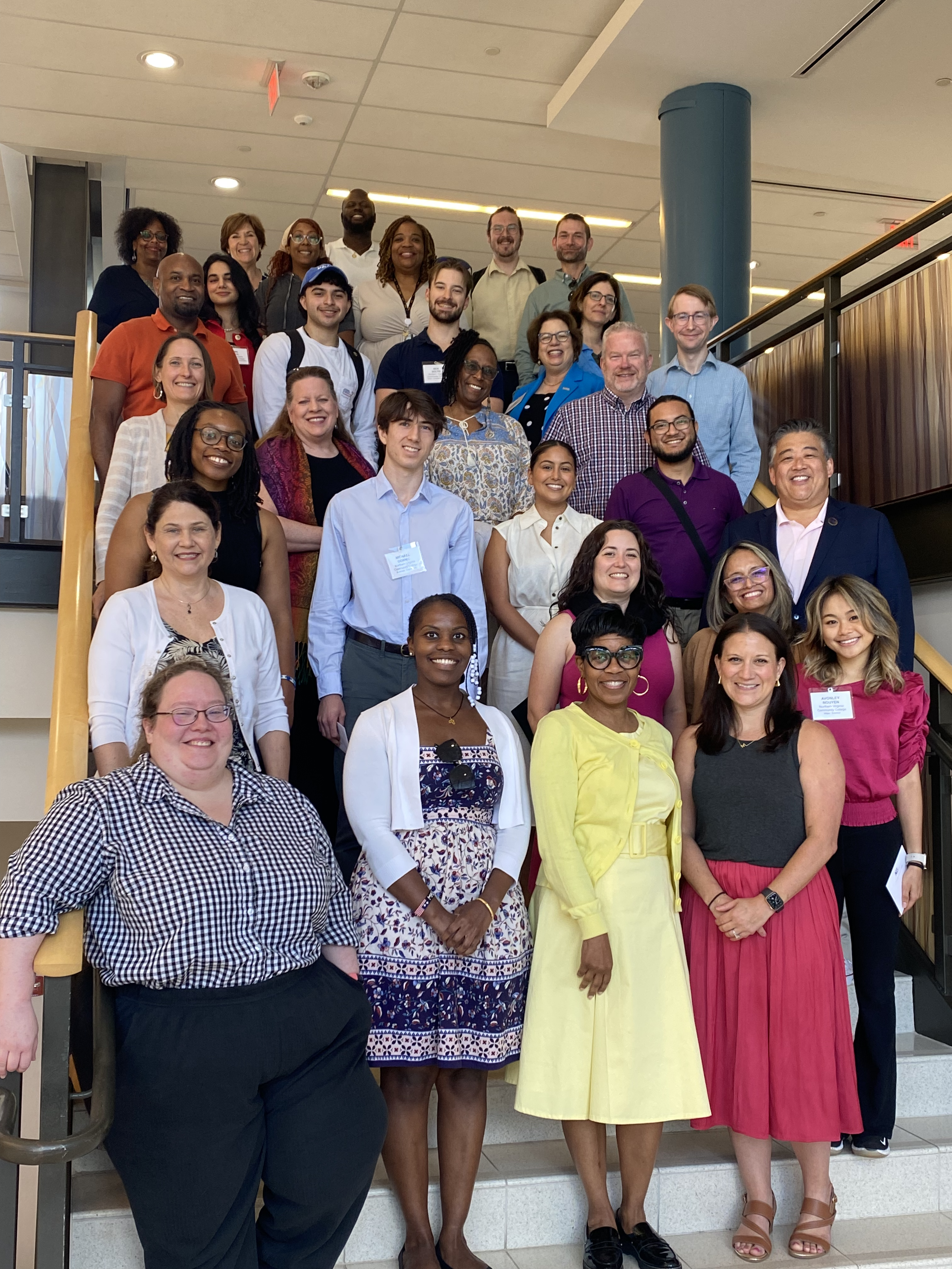 NOVA Loudoun Provost Julie Leidig and NOVA students smile for a photo on the inside steps of the Higher Education Center with Association of Community College Trustees (ACCT) staff members during their visit to the campus on Tuesday, June 11. 