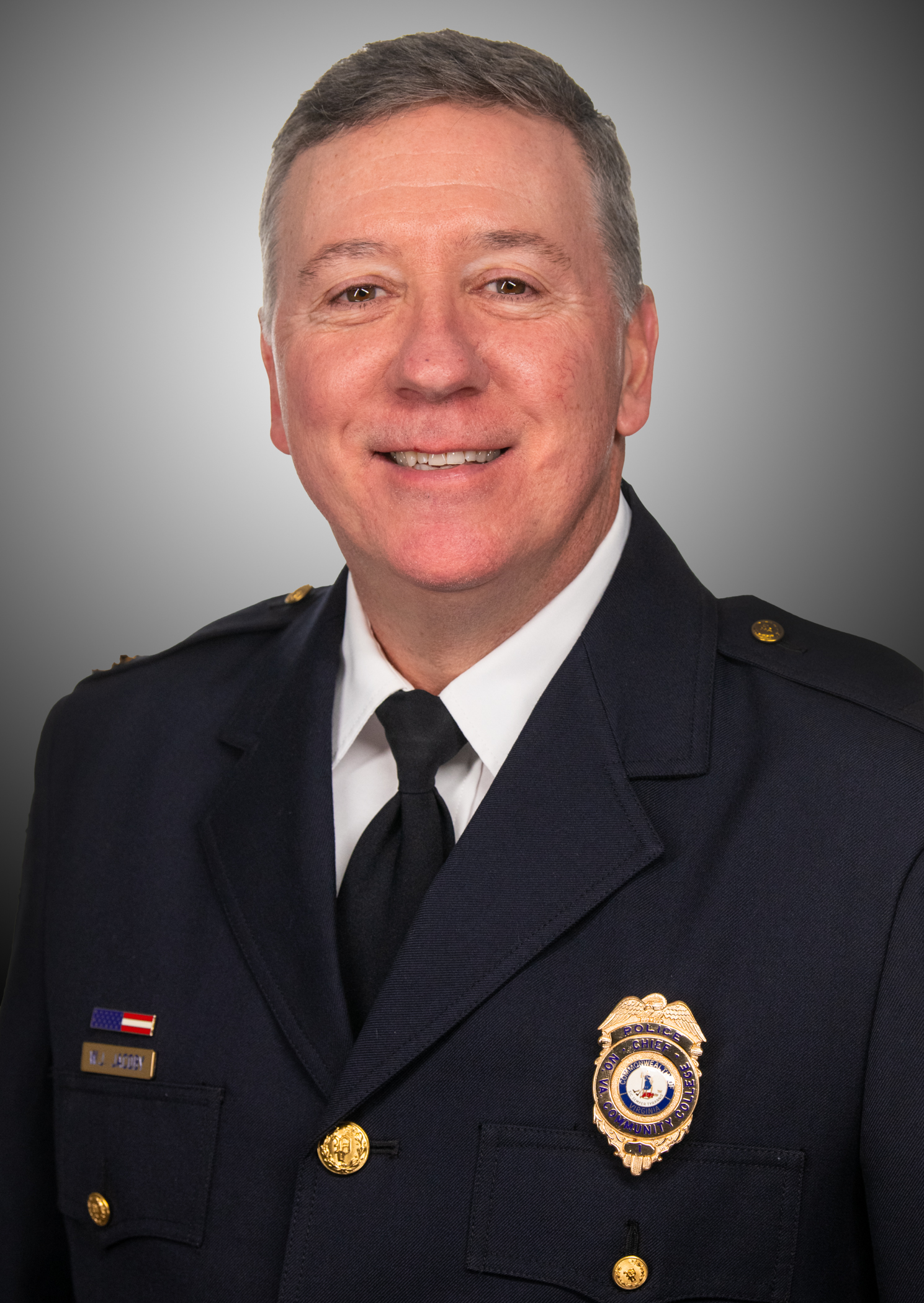 Chief Jake Jacoby poses for a professional portrait wearing his police uniform.