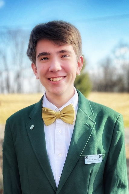 Photo: Jack Woodard stands outdoors on a beautiful day wearing a gold bowtie and a green 4H jacket. 2023 Jack Woodard 4-H ambassador and 4-H Youth-in-Action STEM category award winner