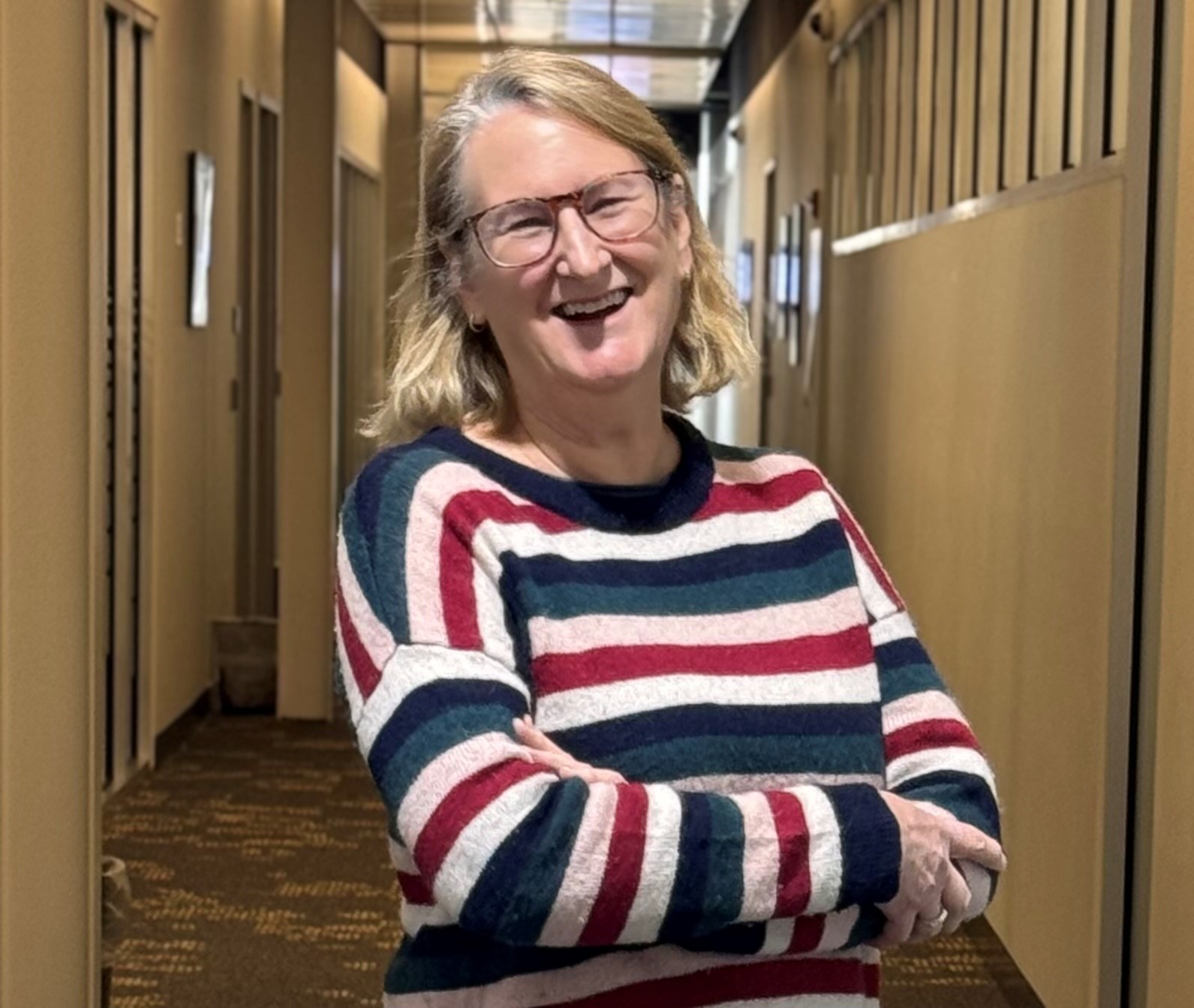 Lynn Reddy smiles as she stands in the hallway of the Pender 4 building.
