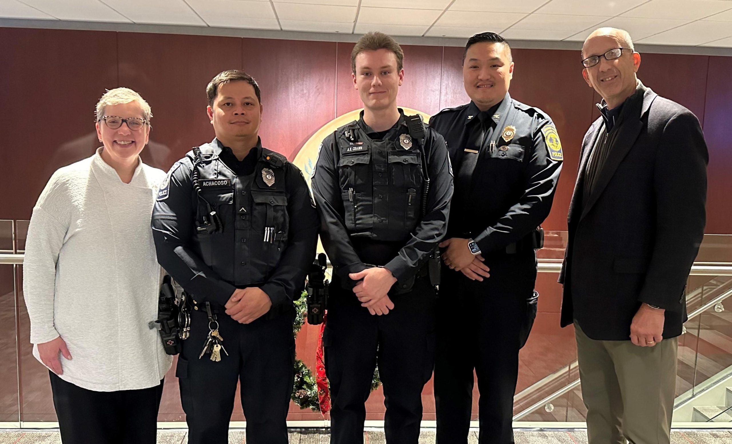 The officers, along with President Kress and VP Ferrari, line up for a photo in the Brault Building. From left to right, President Anne M. Kress; Officer Mark Achacoso; Officer Anthony Crawn; Interim Chief of Police Tony Ong; and Vice President of Finance and Administration John Ferrari.