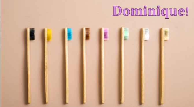 Colorful toothbrushes. Text: Dominique!